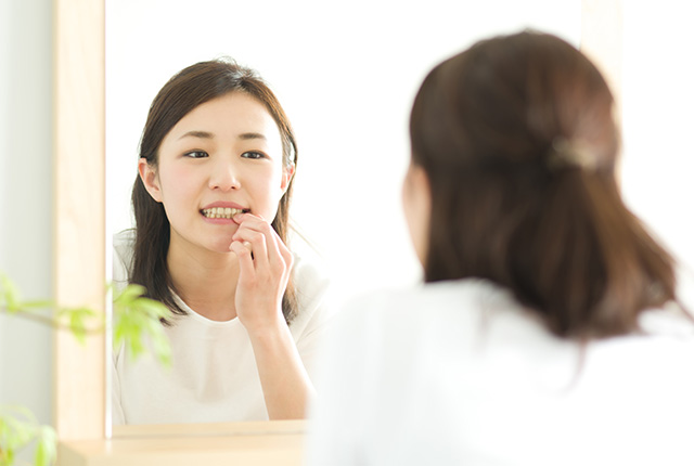 歯を鏡で見る女性