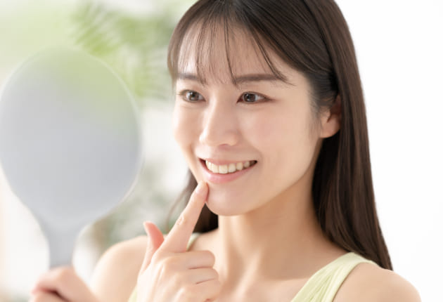 鏡で歯並びを確認する女性